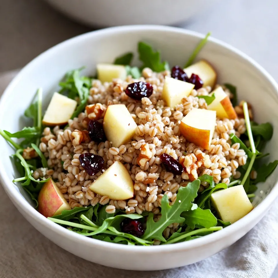 To make the Apple Parmesan Farro Salad, you will need these fresh and wholesome ingredients: - 1 cup farro - 2 cups water or vegetable broth - 1 large apple, diced (preferably a tart variety) - 1/2 cup grated Parmesan cheese - 1/4 cup walnuts, chopped - 1/4 cup dried cranberries - 2 cups arugula or mixed greens - 3 tablespoons olive oil - 2 tablespoons apple cider vinegar - 1 teaspoon honey or maple syrup - Salt and pepper to taste These ingredients blend well together. The farro provides a chewy base. The apple adds a sweet crunch, while the Parmesan gives a salty kick. Walnuts bring a nutty flavor, and cranberries add a touch of tartness. The arugula or mixed greens finish it off with a fresh taste. By using quality ingredients, you create a salad that is vibrant and nutritious. {{ingredient_image_1}} To cook farro, start by rinsing it under cold water. This helps remove any dust or debris. In a medium saucepan, bring 2 cups of water or vegetable broth to a boil. Once boiling, add 1 cup of farro. Reduce the heat to low, cover the pot, and let it simmer for about 30 minutes. You want the farro to be tender but still chewy. After cooking, drain any extra liquid and let the farro cool. While the farro cools, prepare the dressing. In a small bowl, whisk together 3 tablespoons of olive oil, 2 tablespoons of apple cider vinegar, and 1 teaspoon of honey or maple syrup. Add a pinch of salt and pepper to taste. Mix it well until the dressing is combined. This dressing adds a nice tangy flavor to the salad. In a large salad bowl, combine the cooled farro, 1 large diced apple, 1/2 cup of grated Parmesan cheese, 1/4 cup of chopped walnuts, and 1/4 cup of dried cranberries. These ingredients bring texture and flavor to the dish. Drizzle the dressing over the salad and toss everything gently until it is well coated. Finally, fold in 2 cups of arugula or mixed greens to give the salad a fresh touch. Taste and adjust seasoning if needed. Enjoy your vibrant and nutritious Apple Parmesan Farro Salad! For this salad, a tart apple shines. Good choices include Granny Smith, Honeycrisp, or Fuji. These varieties bring a crisp bite and a good balance of sweet and sour. When picking apples, look for firm skin without bruises. A fresh apple should feel heavy for its size. For greens, arugula adds a peppery kick. You can also use mixed greens for a milder flavor. Choose greens that are bright and crisp. Avoid wilted or discolored leaves. Fresh greens make the salad pop. To boost taste, consider adding herbs. Fresh basil or parsley can brighten the dish. A sprinkle of black pepper enhances the flavor profile as well. If you want a bit more zing, add a pinch of red pepper flakes. When making the dressing, taste as you go. Adjust salt or honey to find your perfect balance. If you want a touch of sweetness, maple syrup works wonders. You can also swap the vinegar for lemon juice for a fresh twist. Cooking farro is simple, but a few mistakes can happen. Make sure to rinse it well before cooking. This removes excess starch. Use a pot with a tight lid to keep the steam in. Cook farro on low heat for about 30 minutes. It should be tender but still chewy. Drain any extra liquid, but don’t let it sit too long. This keeps it from becoming mushy. If you follow these tips, your farro will have a great texture. Pro Tips Choose the Right Apple: Opt for a tart apple variety like Granny Smith for a refreshing contrast to the savory Parmesan. Toast the Walnuts: Toasting walnuts in a dry skillet enhances their flavor and adds a delightful crunch to the salad. Make it Ahead: Prepare the farro and dressing in advance to save time. Assemble the salad just before serving for freshness. Customize Your Greens: Feel free to mix in other greens like spinach or kale for added nutrients and flavor variety. {{image_2}} If you need gluten-free options for farro, try quinoa or brown rice. Both work well and have a nice texture. They are easy to find in stores. For those who want a vegan twist, use nutritional yeast instead of Parmesan cheese. It adds a cheesy flavor and is packed with nutrients. To make the salad even better, add roasted vegetables like sweet potatoes or bell peppers. They add warmth and extra taste. You can also customize your dish with seasonal fruits or nuts. Try pears or pomegranate seeds for a twist. You can also use almonds or pecans for crunch. Mix up your dressing by using balsamic or red wine vinegar. Each type gives a unique flavor. If you want a sweeter touch, swap honey for agave syrup or maple syrup. These options can change the whole vibe of your salad. Feel free to experiment until you find the perfect taste! To keep your Apple Parmesan Farro Salad fresh, store it in an airtight container. This helps lock in moisture and flavor. Make sure to keep the salad in the fridge. It will stay good for about 3 days. After that, the ingredients may lose their crunch and taste. You can make this salad in parts to save time. Cook the farro ahead of time and let it cool. Store the farro in the fridge for up to 4 days. You can also prepare the dressing in advance. Keep the dressing in a separate container. Mix it with the salad right before serving to keep it fresh. Freezing farro salad is not ideal. The texture changes when thawed. If you want to freeze farro, do it alone. Cooked farro can freeze well for up to 3 months. When ready to use, thaw it overnight in the fridge. Warm it gently and then mix it with fresh ingredients for serving. Yes, you can prepare this salad ahead of time. Cook the farro and let it cool. You can mix the salad without the greens and dressing. Store it in the fridge for up to two days. When you are ready to serve, add the greens and dressing. This keeps everything fresh and crisp. If you need a substitute for Parmesan cheese, try nutritional yeast for a vegan option. You can also use pecorino cheese for a similar taste. Feta cheese adds a nice flavor too. Choose what fits your taste best. No, farro is not gluten-free. It contains gluten, so it is not safe for those with celiac disease or gluten sensitivity. If you need a gluten-free grain, try quinoa or brown rice. These options work well in salads and have a similar texture. You can easily customize this salad for various diets. For a vegan option, skip the cheese and use maple syrup instead of honey. To make it gluten-free, swap farro for quinoa or rice. Add different nuts or seeds for extra crunch. You can also add more veggies like bell peppers or cucumbers for added nutrients. This blog post showed how to make a delicious farro salad. You learned about the key ingredients, step-by-step cooking instructions, and tips to enhance flavor. We also discussed variations for different diets and how to store leftovers. Farro salad is tasty, healthy, and easy to customize. Using fresh ingredients makes a big difference. Enjoy experimenting and making this dish your own! Your kitchen can become a place of creativity and fun with farro salad.